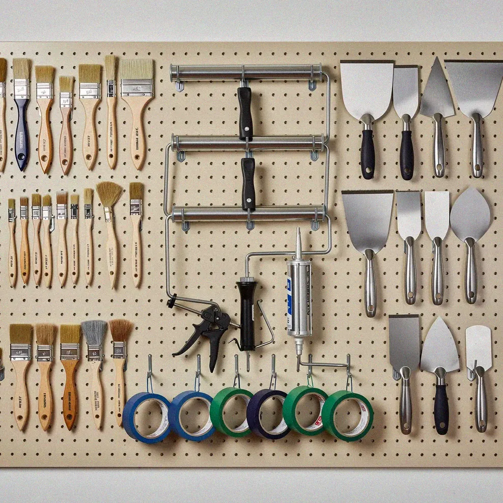 Neatly organized painting tools on a workshop pegboard