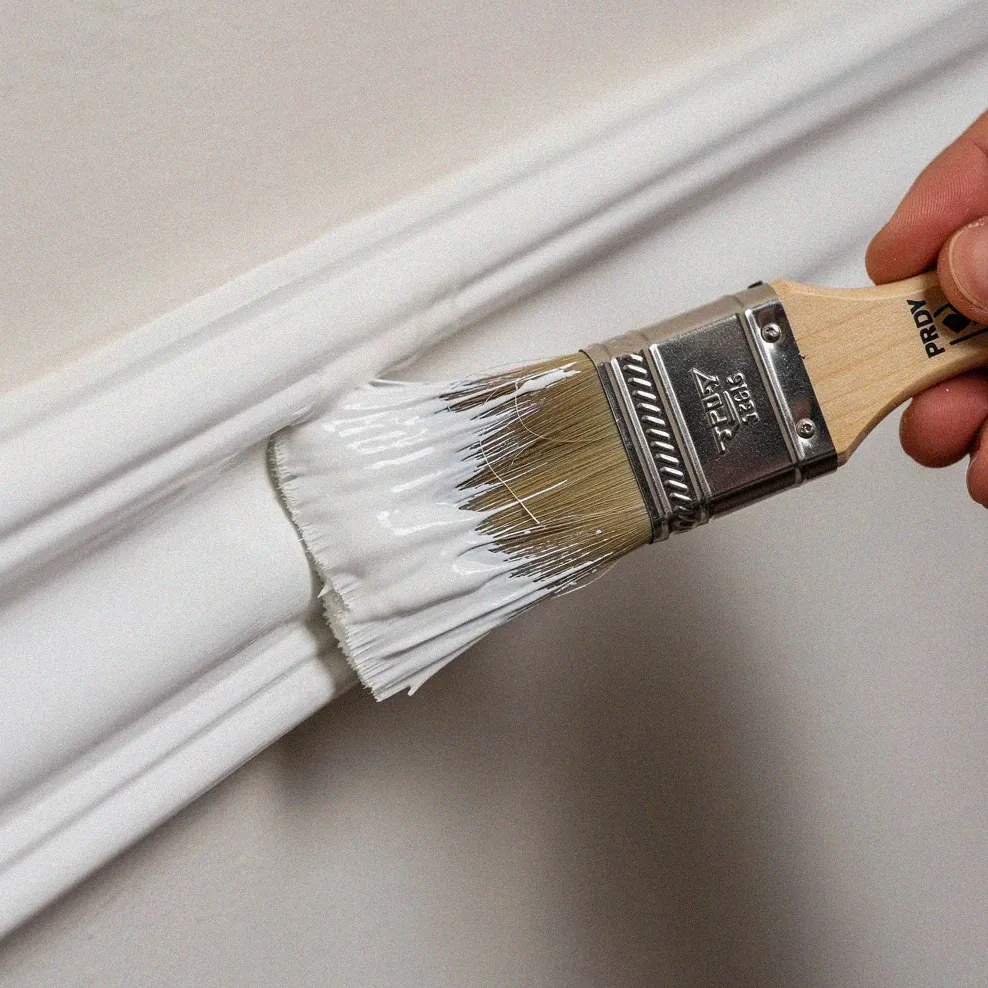 High-quality paintbrush making a smooth stroke along crown molding